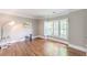 Bright living room features hardwood floors and a window with plantation shutters at 9175 Etching Overlook, Johns Creek, GA 30097