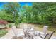 Cozy stone patio with outdoor seating, surrounded by a lush, green landscape perfect for relaxing and entertaining at 9175 Etching Overlook, Johns Creek, GA 30097