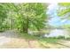 Scenic view of a tranquil pond with a fountain, surrounded by lush greenery and walking paths at 9175 Etching Overlook, Johns Creek, GA 30097