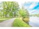 Peaceful walking path along the lake, lined with mature trees and verdant grass at 9175 Etching Overlook, Johns Creek, GA 30097