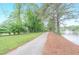 Serene walking path with mature trees lining the pond's edge, perfect for a leisurely stroll at 9175 Etching Overlook, Johns Creek, GA 30097