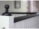 Close up of a banister featuring a round finial atop a white post with a long, black banister at 30 Sessions Nw St, Marietta, GA 30060