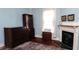 Cozy bedroom showcasing hardwood floors, antique furniture, a white fireplace, and soft natural light at 30 Sessions Nw St, Marietta, GA 30060
