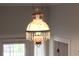 Classic chandelier with floral pattern on the glass globe and crystals dangling from a bronze rim at 30 Sessions Nw St, Marietta, GA 30060