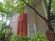 Side of a two-story home with a brick chimney and neutral siding, surrounded by lush greenery at 30 Sessions Nw St, Marietta, GA 30060