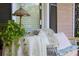 Close up of the front porch with wicker sofa, pillows, side table and table lamp at 30 Sessions Nw St, Marietta, GA 30060