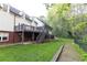 Backyard features a deck, screened in porch, and stairs leading to the yard and a line of trees at 3380 Hill Forest Nw Trl, Acworth, GA 30101