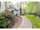 A beautiful backyard features a paved path with a garden alongside the house and a fenced in grassy area at 3380 Hill Forest Nw Trl, Acworth, GA 30101