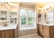 Bright bathroom featuring double vanities, built-in shelving, and a window seat with natural light at 3380 Hill Forest Nw Trl, Acworth, GA 30101