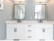 Bright bathroom featuring dual sinks, white cabinets, black hardware, and large mirrors at 3380 Hill Forest Nw Trl, Acworth, GA 30101