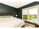 Comfortable bedroom with hardwood floors, natural light, and backyard pool views at 3380 Hill Forest Nw Trl, Acworth, GA 30101