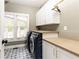 Convenient laundry room with modern appliances, built-in cabinetry, and stylish patterned flooring at 3380 Hill Forest Nw Trl, Acworth, GA 30101