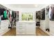 Spacious walk-in closet with custom shelving, drawers, and a center island for ample storage and organization at 3380 Hill Forest Nw Trl, Acworth, GA 30101