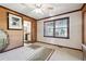 Neutral bedroom featuring textured wall accents, updated ceiling fan, and sunlit window view at 8145 Stone Hill Rd, Cumming, GA 30028