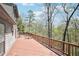 Expansive deck with railings offering panoramic views of the surrounding wooded landscape at 8145 Stone Hill Rd, Cumming, GA 30028