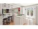 Bright kitchen with white cabinets, island with cooktop, and breakfast bar at 8145 Stone Hill Rd, Cumming, GA 30028