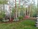 Landscaped front yard featuring a stone-lined garden bed with a variety of plants and trees at 8145 Stone Hill Rd, Cumming, GA 30028