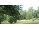 Expansive lawn with mature trees and landscaping offers a serene and private setting at 8145 Stone Hill Rd, Cumming, GA 30028