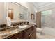 Bathroom featuring a marble countertop, decorative mirror, and a shower-tub combination at 1273 Promontory Ln, Marietta, GA 30062