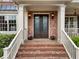 Close-up of the elegant double front doors, complemented by brick steps and stylish lighting fixtures at 1273 Promontory Ln, Marietta, GA 30062