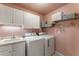 Functional laundry room equipped with a sink, washer, dryer, and storage cabinets at 1273 Promontory Ln, Marietta, GA 30062