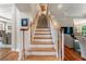 Open staircase with wooden handrail and white balusters, hardwood floors, and views into dining and living room spaces at 1273 Promontory Ln, Marietta, GA 30062