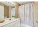 This bathroom features a spacious vanity with a wide mirror and a shower with patterned shower curtain at 4004 Edgecomb Dr, Roswell, GA 30075