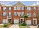 Attractive brick townhome exterior featuring a three-story facade, symmetrical windows, and well-maintained landscaping at 4004 Edgecomb Dr, Roswell, GA 30075