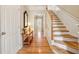 Inviting foyer with hardwood floors, staircase, console table and classic decor at 4004 Edgecomb Dr, Roswell, GA 30075