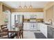 Well-lit kitchen featuring white cabinets, stainless steel appliances, and eat-in dining area at 4004 Edgecomb Dr, Roswell, GA 30075