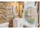 Stylish half-bathroom with patterned wallpaper, marble vanity, and natural light at 4004 Edgecomb Dr, Roswell, GA 30075