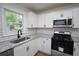 A bright kitchen featuring white cabinets, stainless steel appliances, and granite countertops at 443 Indian Hills Dr, Dallas, GA 30157