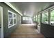 Covered porch with wooden flooring and multiple windows at 443 Indian Hills Dr, Dallas, GA 30157