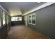 Long, covered porch with wooden flooring and multiple windows at 443 Indian Hills Dr, Dallas, GA 30157