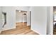 Hallway view leading to the kitchen, showcasing hardwood floors and ample natural light at 8740 Roswell Rd # 9C, Atlanta, GA 30350