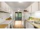 Bright kitchen with modern appliances, white cabinets, and a view to the outdoor balcony at 8740 Roswell Rd # 9C, Atlanta, GA 30350