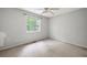 This bedroom has neutral paint, a window overlooking trees, and a ceiling fan at 1034 Hillsborough Nw, Kennesaw, GA 30144