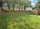 Beautiful back yard featuring lush green grass, and manicured tiered landscaping at 1692 Woodsford Nw Rd, Kennesaw, GA 30152