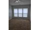 Comfortable bedroom with carpeting and three large windows at 1692 Woodsford Nw Rd, Kennesaw, GA 30152