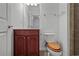 Small bathroom featuring a dark wood vanity with a decorative mirror, white walls and toilet, and tiled shower at 2268 Limehurst Ne Dr # 120, Atlanta, GA 30319