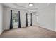 Spacious carpeted bedroom featuring a tray ceiling, recessed lighting, and two windows with beautiful dark blue draperies at 2268 Limehurst Ne Dr # 120, Atlanta, GA 30319