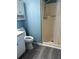 Cozy bathroom featuring blue walls, gray wood look flooring, a white vanity, and stand up shower at 260 Amanda Ct, Stockbridge, GA 30281