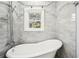 Bright bathroom features a classic soaking tub with tiled walls and a window for natural light at 39 Wyman Se St, Atlanta, GA 30317