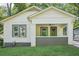 Close-up of a classic white bungalow featuring a cozy front porch with painted brick accents at 39 Wyman Se St, Atlanta, GA 30317