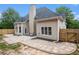 An airy backyard with a brick patio, light siding, dark accents and lots of trees surrounding the grassy lawn at 448 Cape Ivey Dr, Dacula, GA 30019