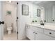 Bright bathroom with white vanity, framed mirror, modern fixtures, and a toilet next to a shower behind an opened door at 448 Cape Ivey Dr, Dacula, GA 30019