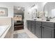 Luxurious bathroom with double vanity, grey cabinets, and soaking tub, offering a spa-like experience at 448 Cape Ivey Dr, Dacula, GA 30019