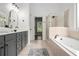 Bright bathroom featuring a soaking tub, separate shower, and dual vanity, creating a functional design at 448 Cape Ivey Dr, Dacula, GA 30019