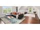 Spacious bonus room with a large window, a vaulted ceiling, a dark leather couch, a coffee table, and a light colored rug at 448 Cape Ivey Dr, Dacula, GA 30019