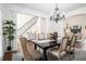 Elegant dining room with a chandelier, wood floors, and staircase access at 448 Cape Ivey Dr, Dacula, GA 30019